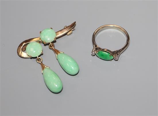A yellow metal and jadeite set double drop brooch and a white metal, jadeite and diamond set three stone ring.